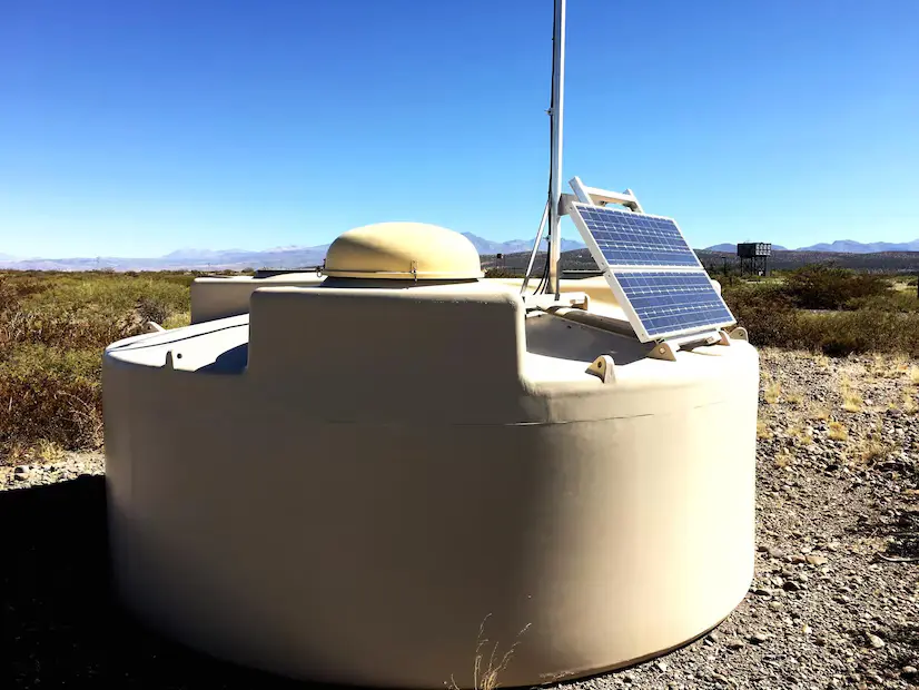 Pompe solaire pour puits dans une ferme avec panneaux solaires sous un ciel bleu clair, capturant l’énergie pour une irrigation agricole durable au Maroc